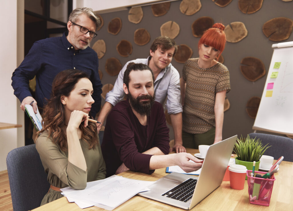 A team of marketers reviewing Facebook Ads frequency cap strategies to optimize ad spend and reduce audience fatigue